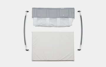 Image of a lay-down of The Bassinet Fabric Assembly, Bassinet Mattress, and Bassinet Rocker Arms
